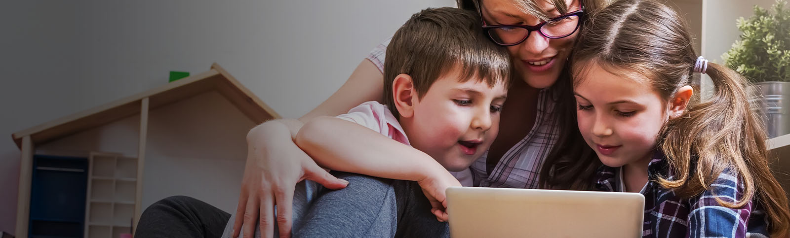 Mother with two children using digital tablet at home.