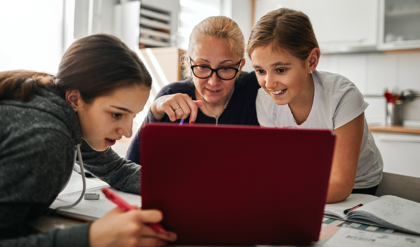 Mother helping her daughters to finish school homework.